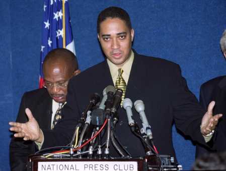 [Rahn Jackson, a plaintiff in a class action suit against Microsoft Corp., talks to the press Wednesday, Jan. 3, 2001, at the National Press Club in Washington, as lead attorney Willie Gary, left, listens.]