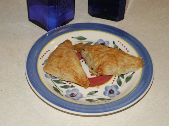 2 pieces of Greek Spanikopita or  Spinach Pie on a saucer