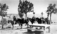 JOHN HANCE (LEFT) AND A MULE PARTY OF 3 DUDES ABOUT TO START DOWN THE BRIGHT ANGEL TRAIL.  BOARDING PLATFORM IN FOREGROUND. CIRCA 1902
