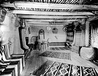UPSTAIRS SALES ROOM IN HOPI HOUSE. BENCHES AROUND ROOM DRAPED WITH NAVAJO RUGS. CIRCA 1905. DETROIT PHOTOGRAPHIC. GRCA 15803B