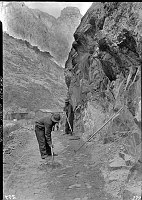WORK ON THE KAIBAB TRAIL IN THE INNER CANYON; 3 MEN WORKING ON TRAIL, BLDGS IN BACKGROUND. 19 DEC 1935. NPS PHOTO.