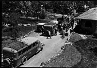 VISITORS BOARDING TOUR BUSES IN FRONT OF EL TOVAR HOTEL. ACUTE ANGLE FROM ROOF. CIRCA 1930. NPS PHOTO