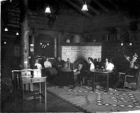 HOTEL EL TOVAR. CORNER OF THE RENDEZVOUS ROOM. 10 GUESTS SITTING AROUND THE MAIN FIREPLACE. 1905