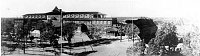 PANORAMIC PHOTOGRAPH OF EL TOVAR HOTEL FRONT ENTRANCE. MULE/ HORSE HITCHING RAILS IN THE FOREGROUND. CIRCA 1907
