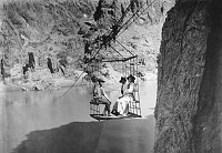 RUST'S AERIAL TRAMWAY CROSSING THE COLORADO RIVER FROM SOUTH TO NORTH SIDE. 2 WOMEN & 1 MAN IN CAGE. CIRCA 1908. KOLB BROS. 