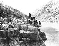 SEVEN MEMBERS OF THE EDGAR FOREST WOLFE PARTY POSE ON A LEDGE BY COLORADO RIVER AT THE  FOOT OF THE BRIGHT ANGEL TRAIL. CIRCA 1903. WOLF, EDGAR FOREST