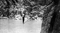 MR SWEENY WALKING CABLE TRAMWAY ACROSS THE COLORADO RIVER. CIRCA 1909. PHOTO BY BROWN.