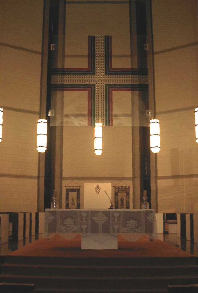 The perspex cross was designed by architect Mr A. E. McCoy, & incorporates the liturgical colours.